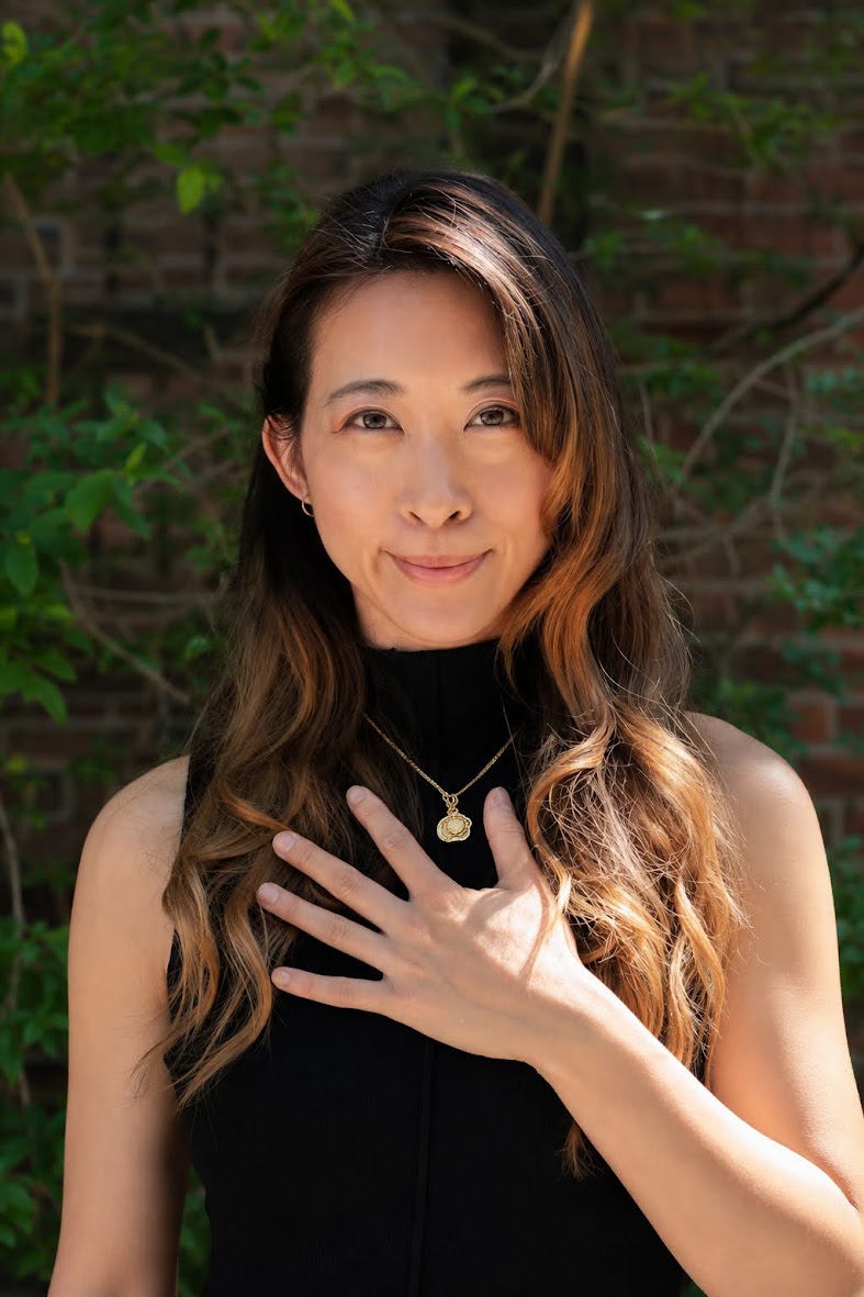 Portrait of Steph Ngan with one hand resting on her chest, looking at the camera